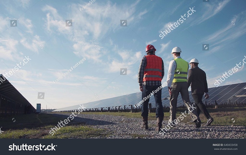 Engineer walking a solar array at sunrise